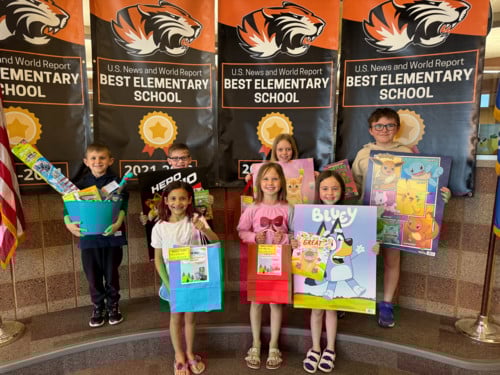 students holding their literacy prizes