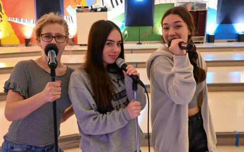 students singing into microphones