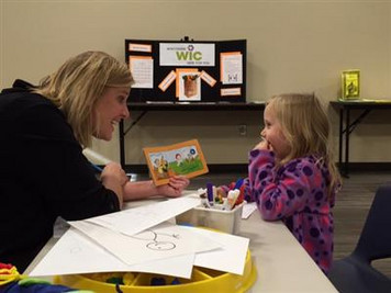 Teacher and student reading a book together