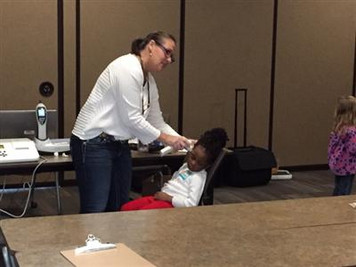 staff member checking student's ears