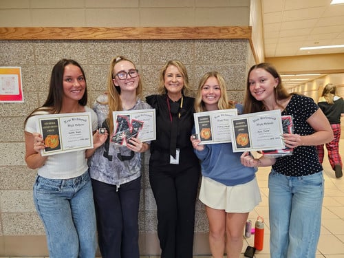 group of high school students holding up academic certificates